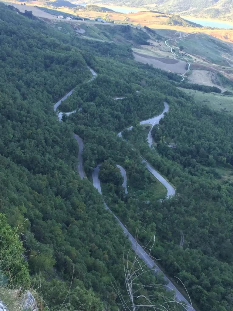 Aerial view of winding mountain road through Abruzzo forest