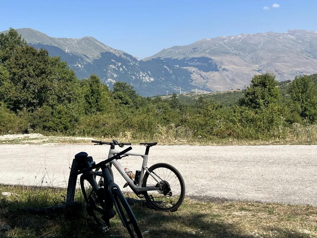 Gravel bike resting on mountain road with Abruzzo peaks behind