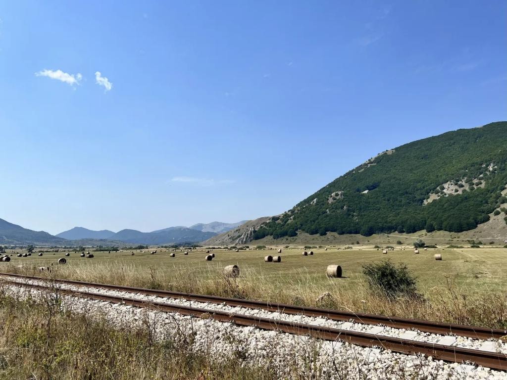 Abruzzo valley with hay bales and mountain railway
