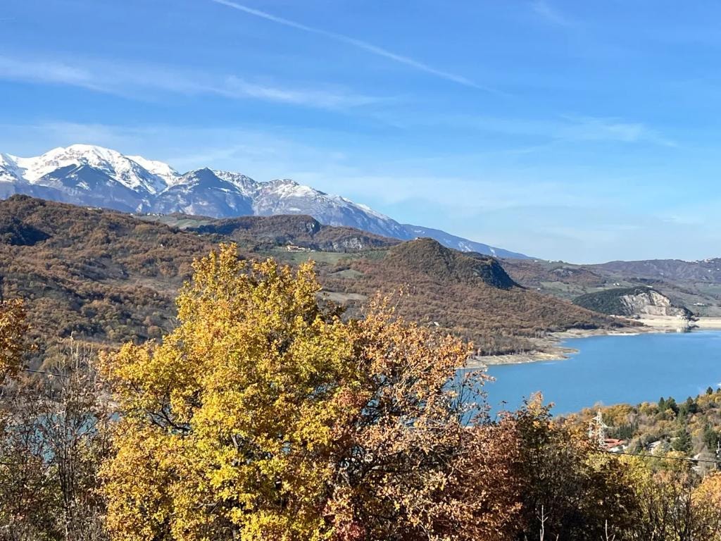 Abruzzo lake and snow-capped mountains in autumn